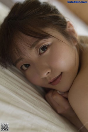 A woman in a blue underwear laying on a bed.