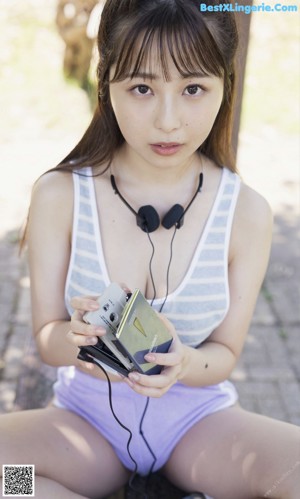 A young woman jogging in a park with headphones on.