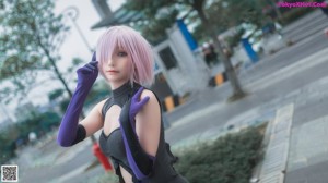 A woman in a black and purple outfit posing for a picture.