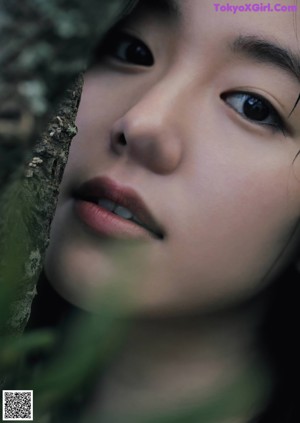 A woman in a blue and white kimono looking up at the sky.