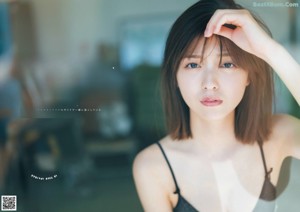 A woman in a black bra and a white shirt.