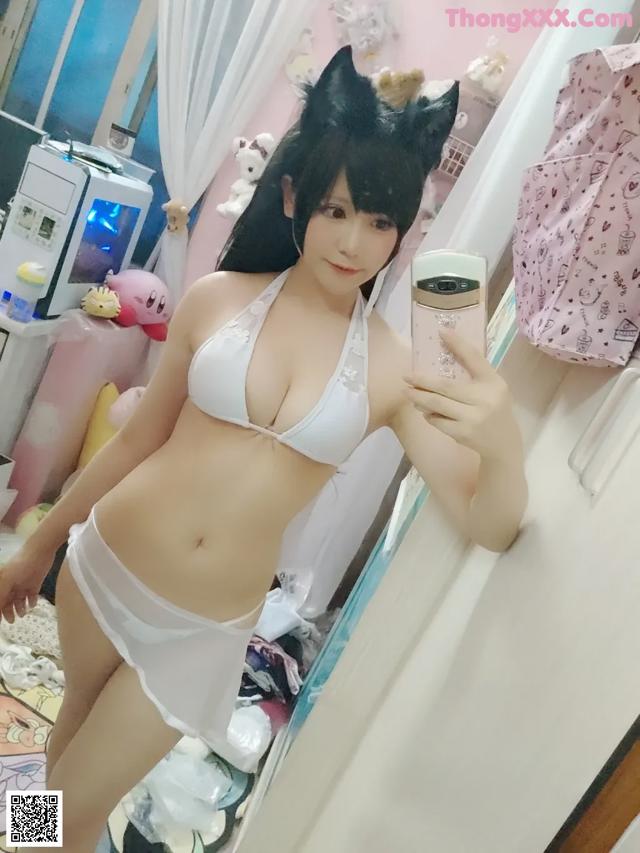A woman in a white bikini taking a selfie.
