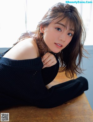 A woman in a blue shirt is posing for a picture.