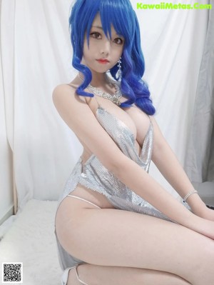 a woman with blue hair sitting on a bed