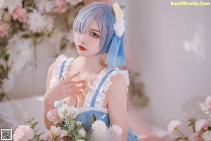 A woman with blue hair holding a bouquet of flowers.