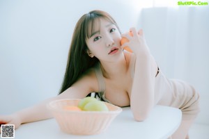 A woman sitting on top of a white bed.