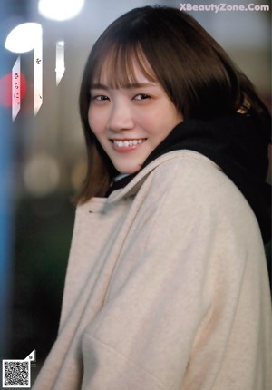 A woman wearing a baseball cap and a scarf.