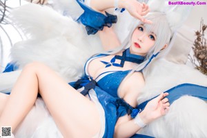 A woman in a blue and white outfit sitting on a chair.