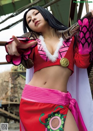 A woman holding a sword in front of a fire.