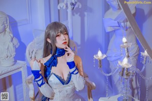 A woman in a white and blue lingerie posing for a picture.