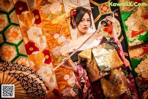 A woman in a kimono holding an umbrella in a city street.