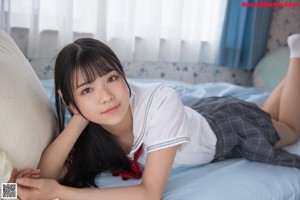 A young woman in a school uniform posing for a picture.
