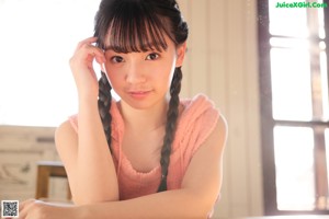 A woman standing in front of a wooden table.