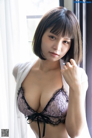 A woman in a black bra and panties sitting on a chair.