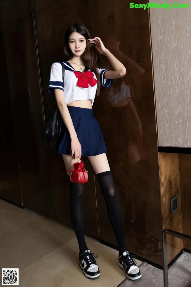 A woman in a sailor outfit posing for a picture.