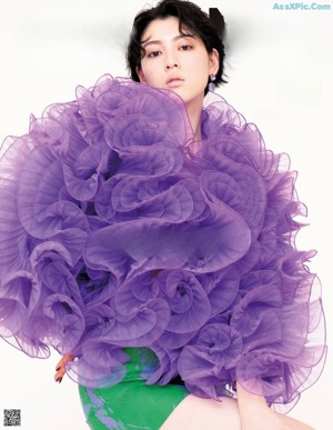 A woman in a purple dress on the cover of a magazine.