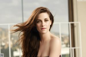 A beautiful young woman with long brown hair posing for a picture.