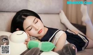 A woman sitting on a couch with a teddy bear.