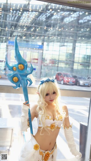 A woman in a white dress holding a blue sword.