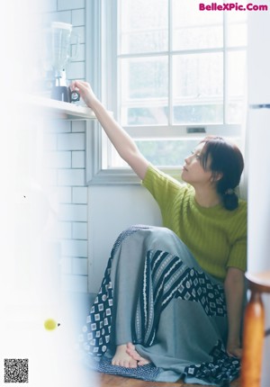 A poster for a Japanese movie with a woman in a green sweater.