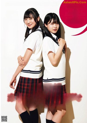 A couple of young women in school uniforms posing for a magazine.