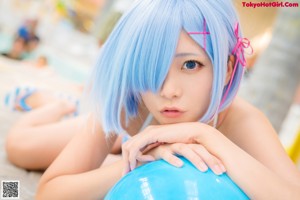 A woman with blue hair holding a blue ball.
