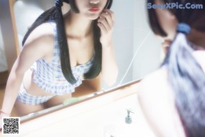 A woman in a blue and white checkered top and shorts.